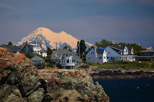 Beautiful homes sit on the Washington coastline with Mt. Rainer in the background.